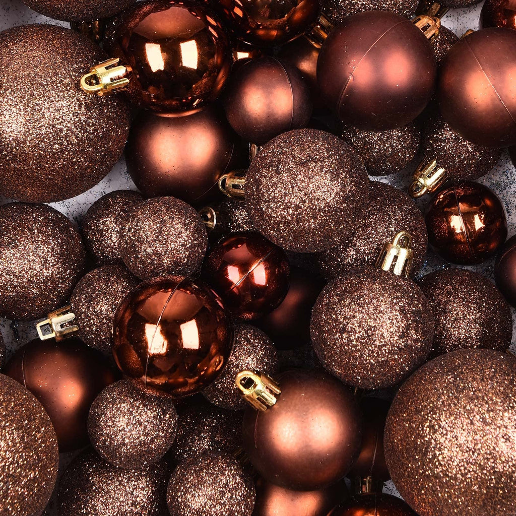 Close-up overhead view of assorted brown Christmas ball ornaments, some glittery and some smooth, with gold caps.