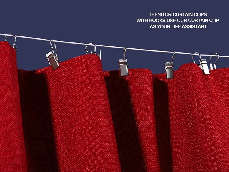 Close-up of small stainless steel curtain clip hooks holding red textured fabric on a white rod against a dark blue background.