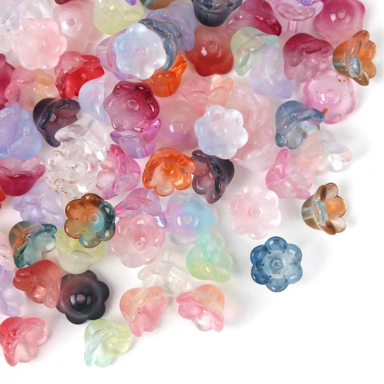 Assortment of colorful glass flower beads scattered on a white background, top-down view.