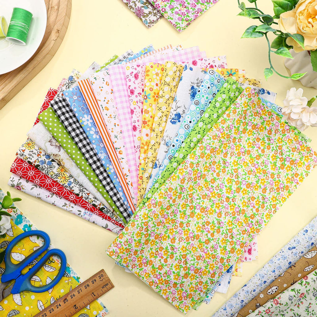 Assortment of 10x10 inch floral printed cotton fabric squares fanned out, with scissors and ruler.