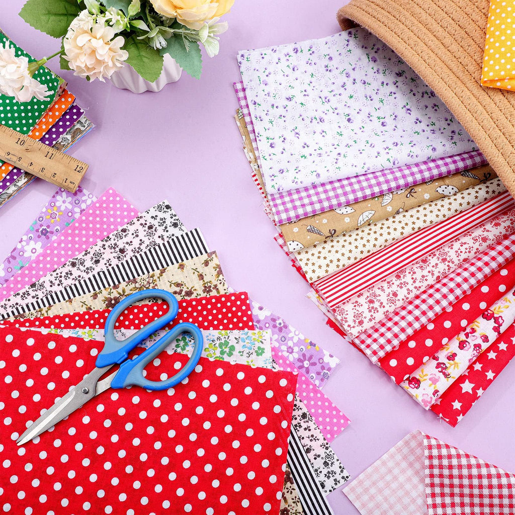 Stack of multicolor floral and patterned fabric squares with blue scissors and a ruler on a lavender background.
