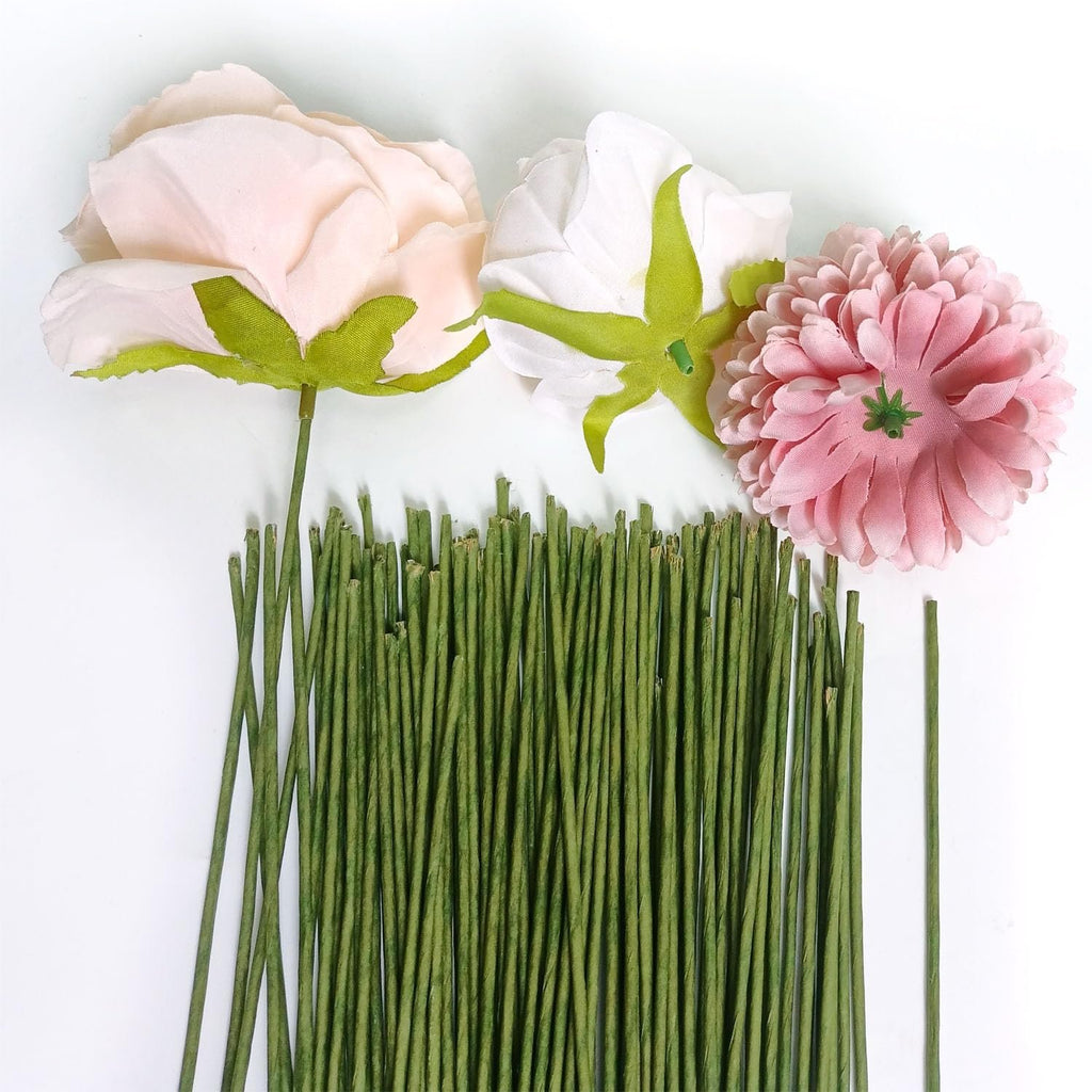 Green floral stem wires arranged with three artificial flowers on a white background