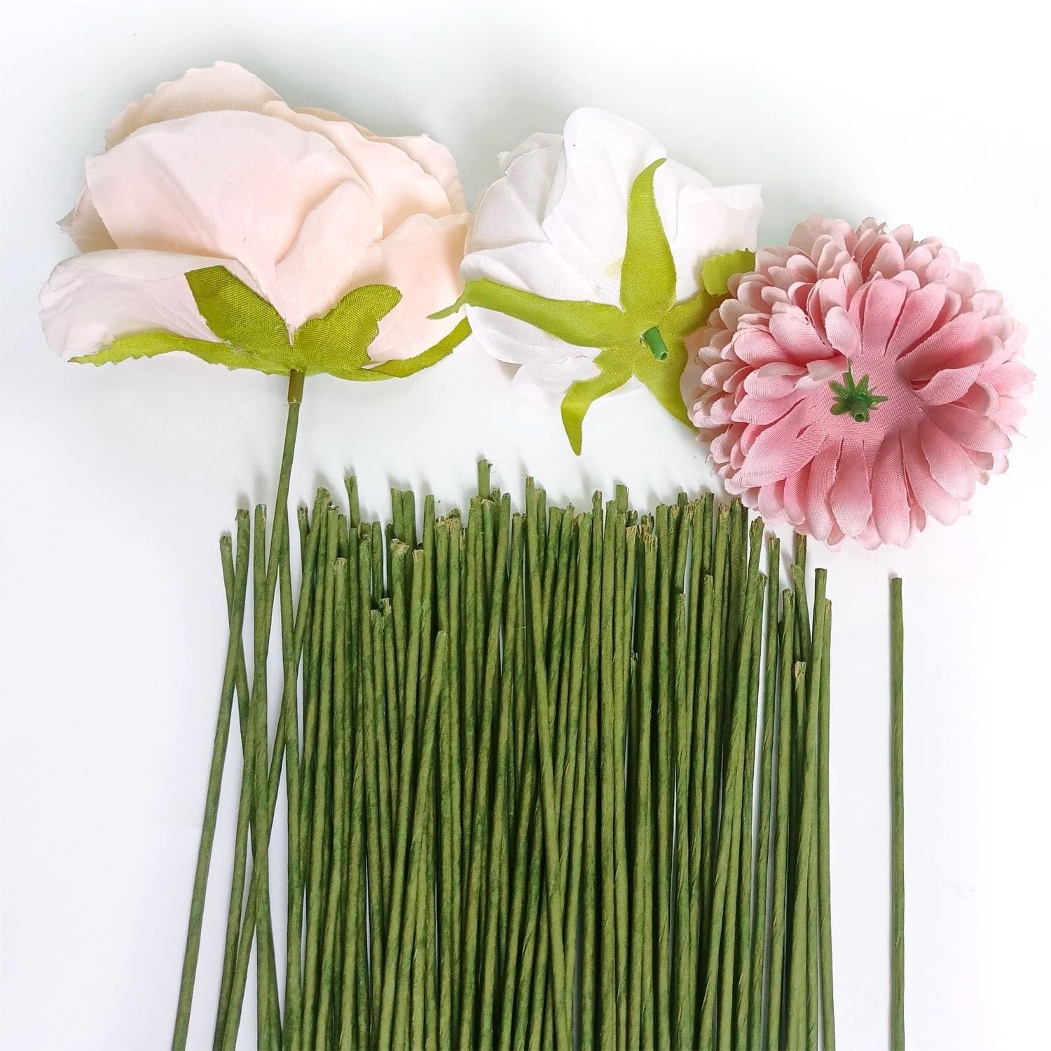Green floral stem wires arranged with three artificial flowers on a white background