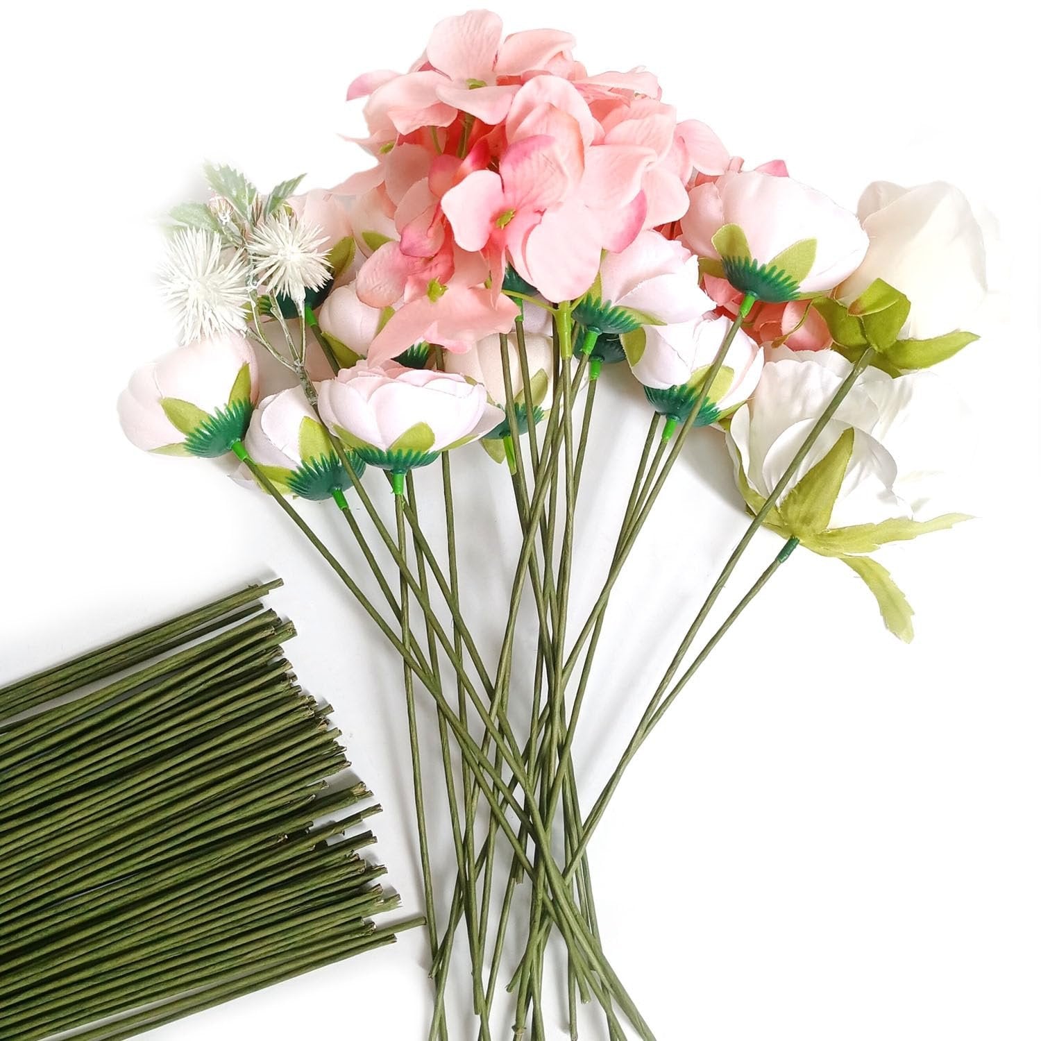 Bundle of green floral stem wires next to artificial flowers including pink and white roses on a white background