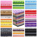Stacks of pre-cut floral and patterned cotton fabric squares in various colors including pink, green, blue, red, yellow, purple, and black.