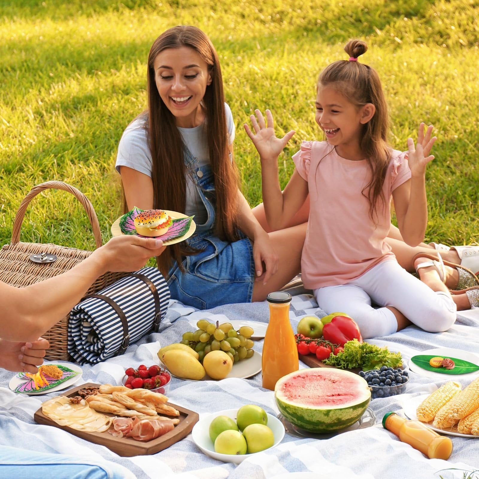 Family enjoying a picnic with food served on tropical leaf-shaped parchment paper