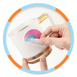 Hands applying a round ocean wave sticker to a white and gold mug. Sticker has pink sky and blue waves.