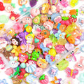 Assorted kawaii resin charms including animals, fruits, and flowers in a clear container.