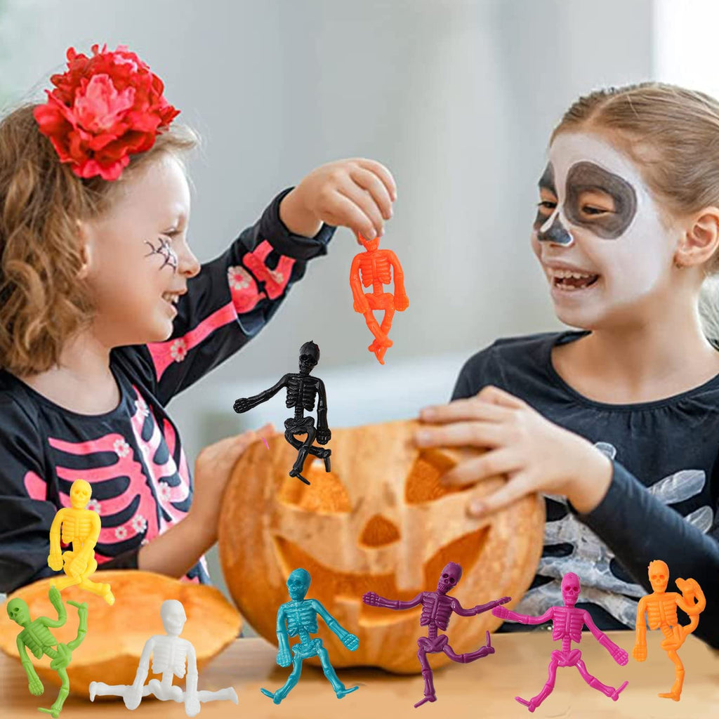 Two children carving a pumpkin with colorful stretchy skeleton toys scattered around them.
