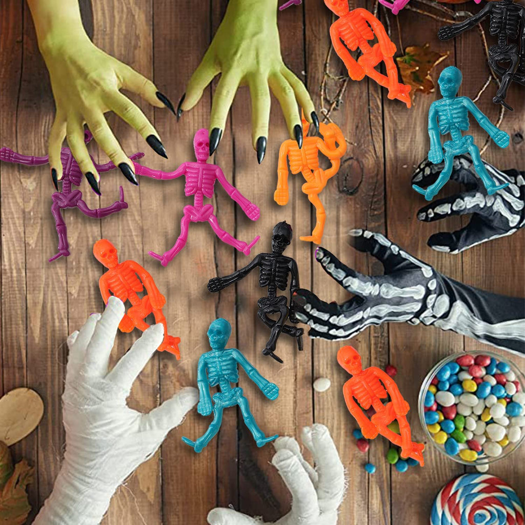 Halloween stretchy skeleton toys in various colors scattered on a wooden surface with mummy hands and skeleton gloves.