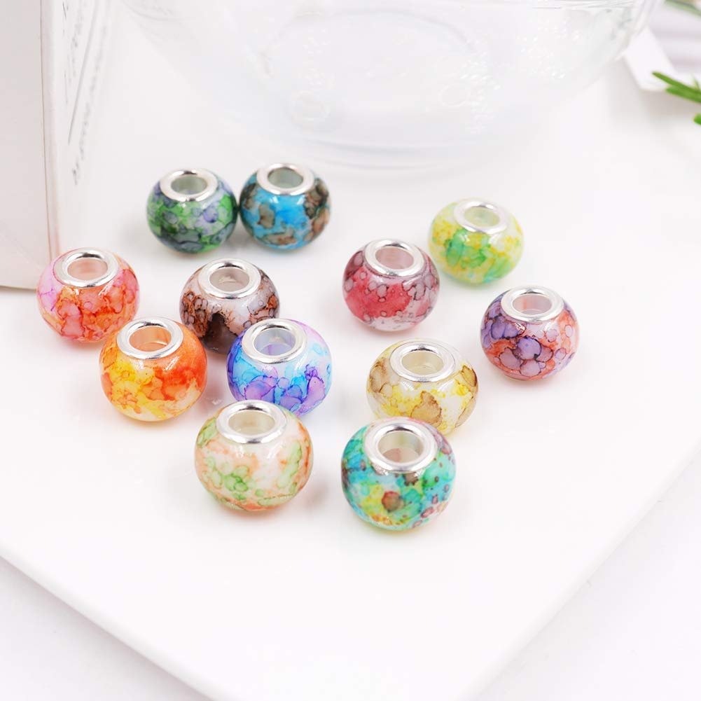 Assortment of colorful glass beads with brass cores arranged on a white surface.