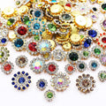 Assortment of mixed color sunflower shape sew-on rhinestones with gold settings on a white background.