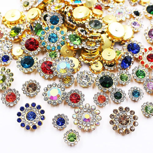 Assortment of mixed color sunflower shape sew-on rhinestones with gold settings on a white background.