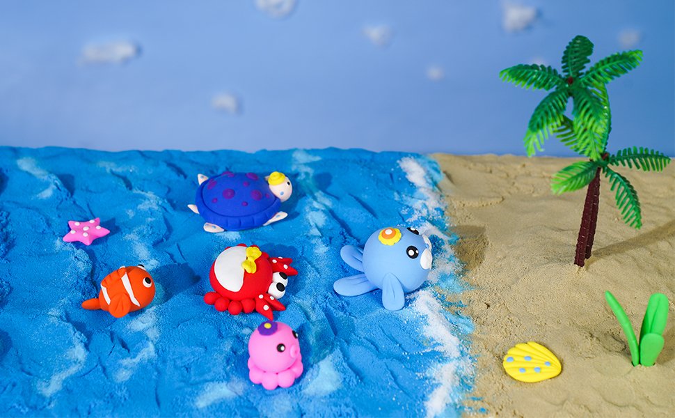 Polymer clay ocean creatures and palm tree on a sandy beach with blue water