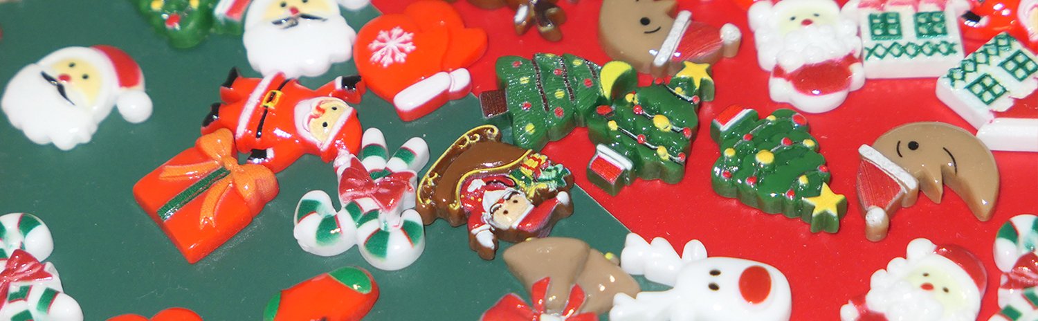 Assorted 3D resin Christmas charms including Santa, Christmas trees, candy canes, and reindeer scattered on a green and red surface.