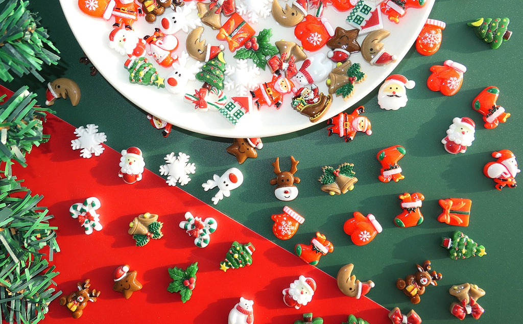 Assorted 3D Christmas resin charms including Santa, reindeer, snowflakes, and trees on a white plate and red/green background.