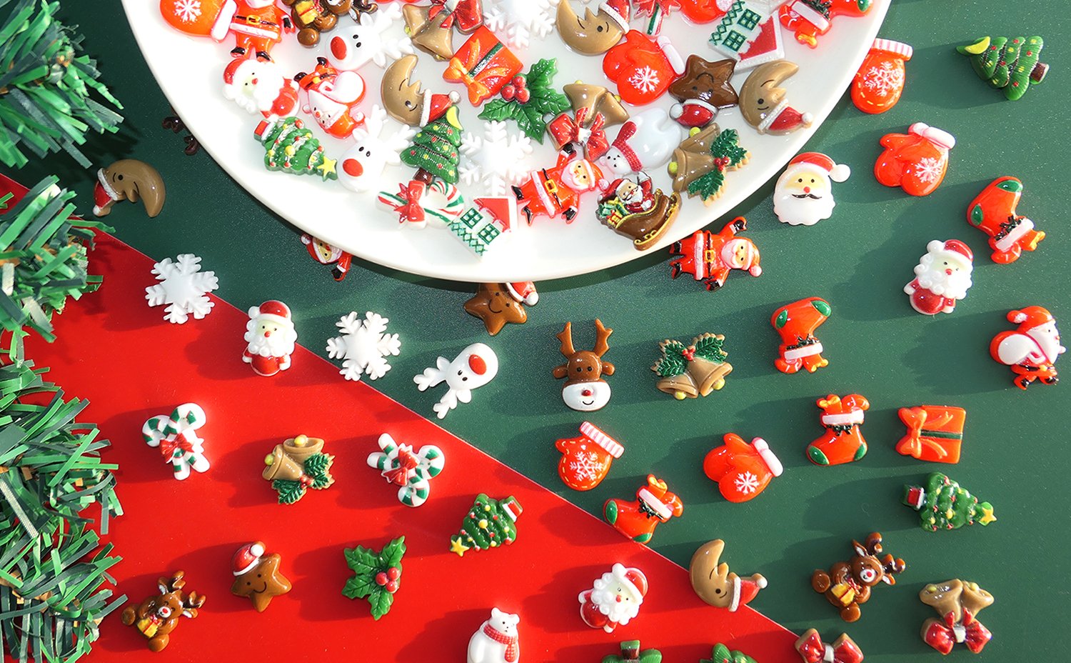 Assorted 3D Christmas resin charms including Santa, reindeer, snowflakes, and trees on a white plate and red/green background.
