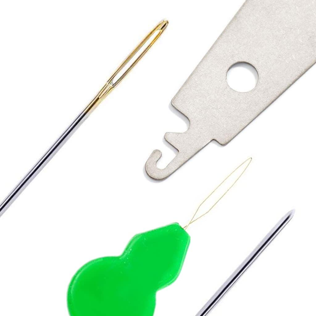Close-up of sewing needles and threaders on a white background, showing a golden-eyed needle, a green threader, and a metal threader tool.