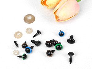 Assorted sizes of black plastic safety eyes with washers and screws, with a pink and yellow tulip in the background.