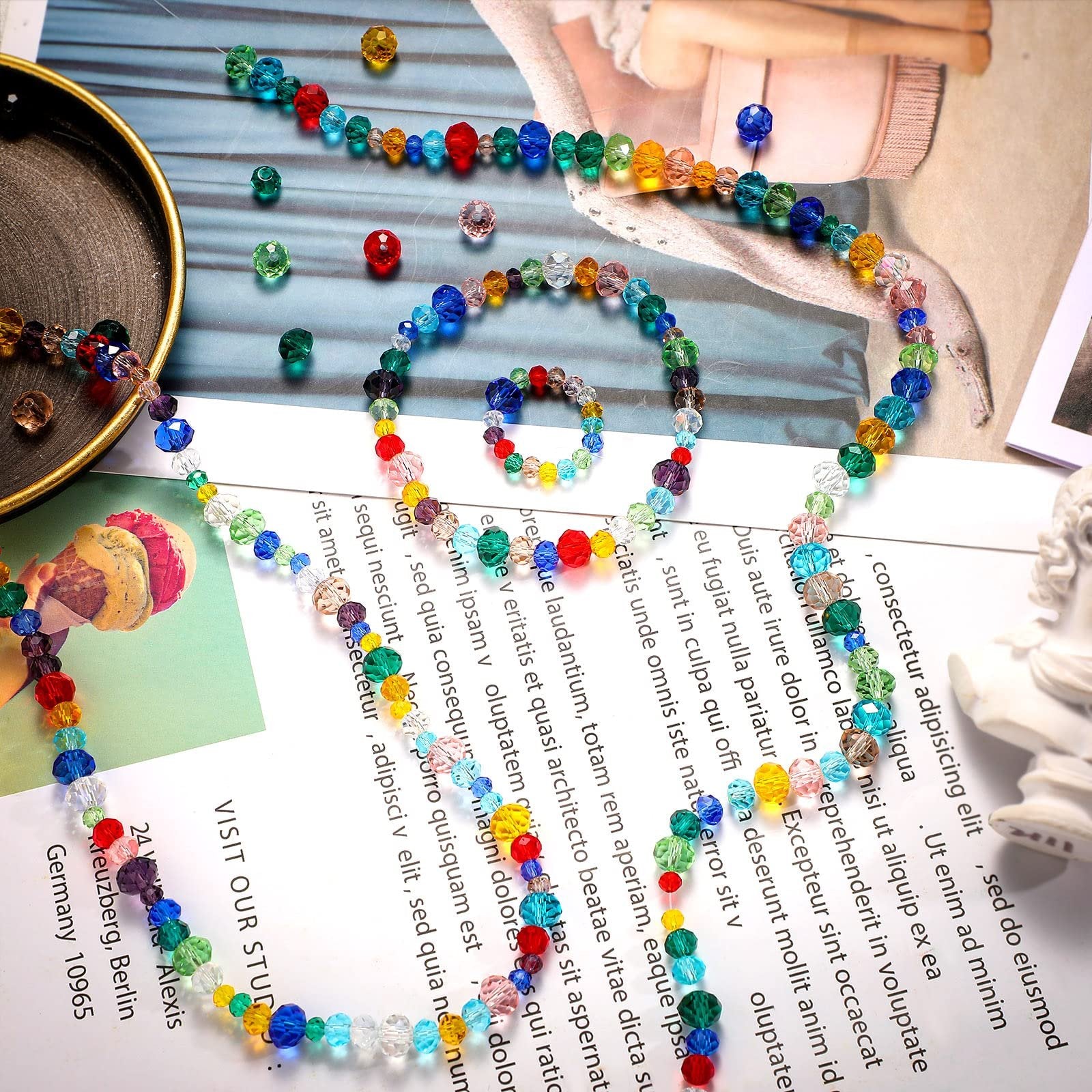 Assortment of colorful faceted glass beads arranged into a necklace and bracelet on a white surface with text.