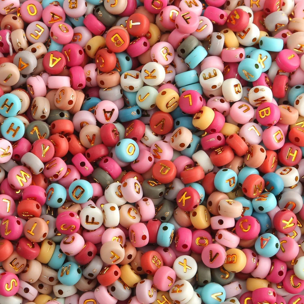 Pile of colorful round acrylic letter beads with gold letters for jewelry making