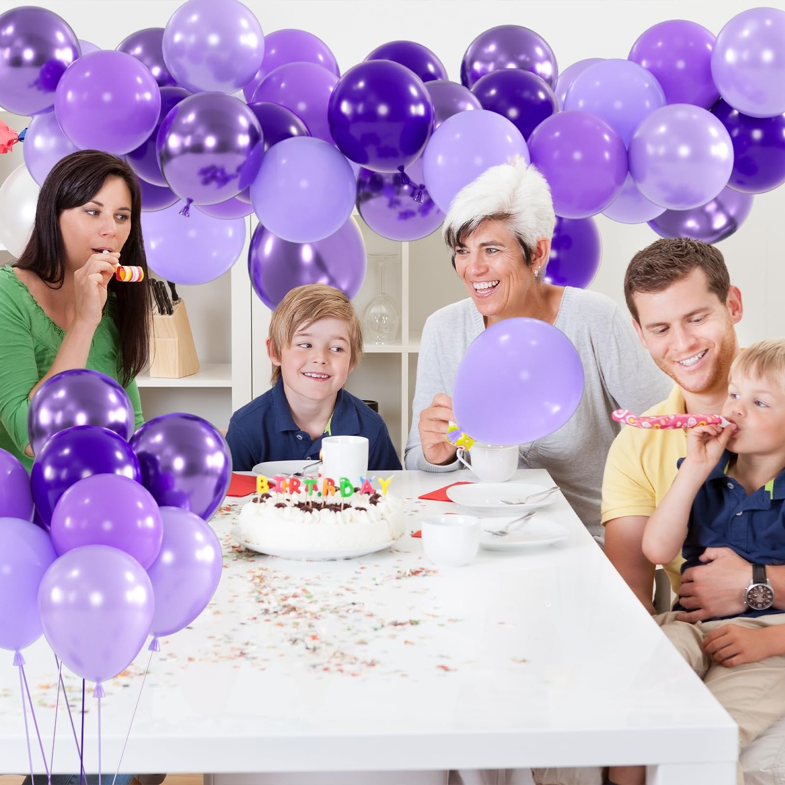 Family celebrating a birthday with purple balloons and a cake