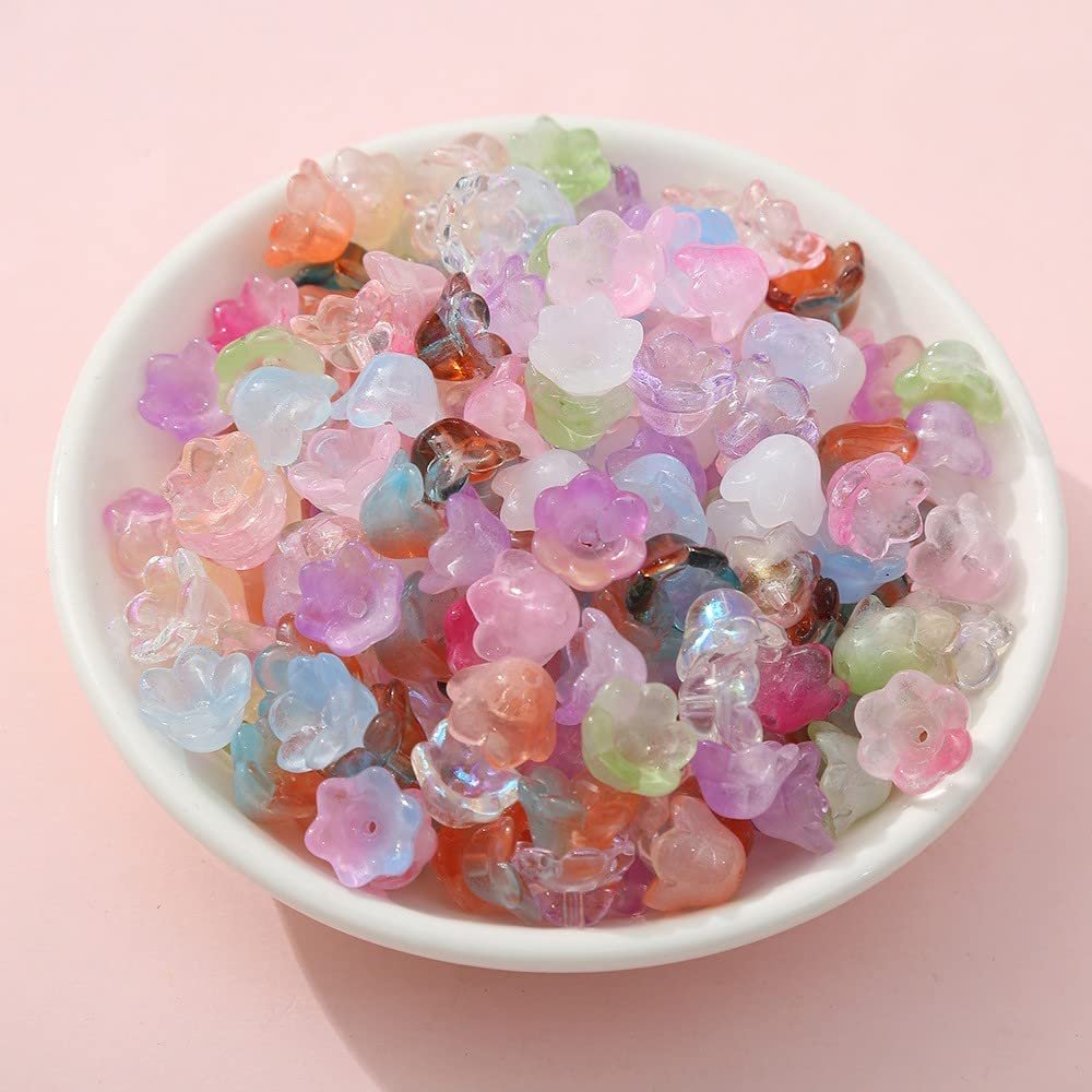 Mixed color glass bellflower trumpet beads in a white bowl, close-up view