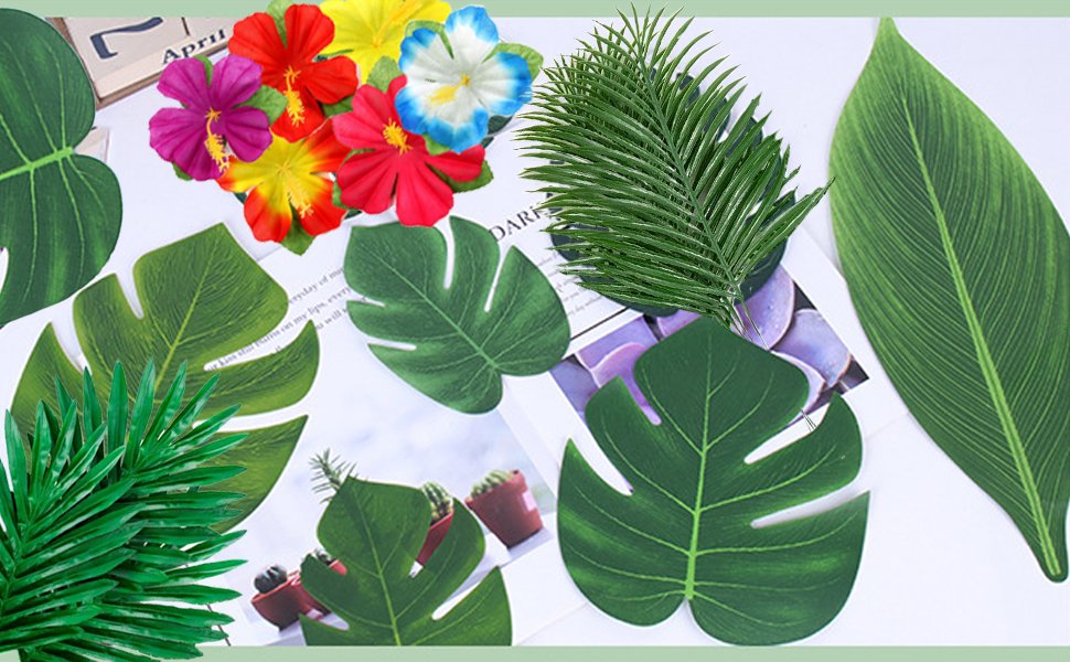 Assortment of artificial tropical leaves and hibiscus flowers in various colors, arranged on a light background.