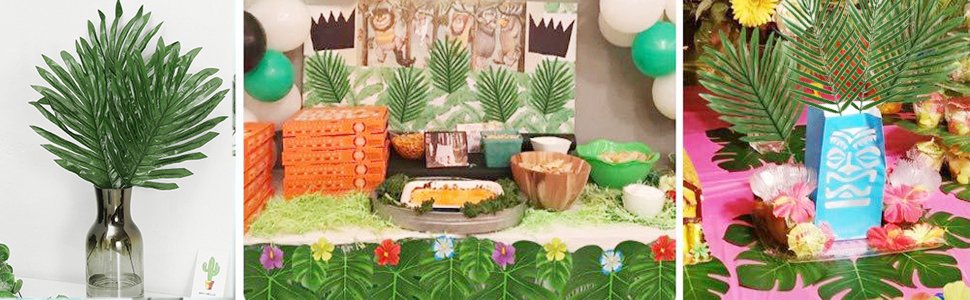 Artificial palm leaves and tropical flowers arranged for a party setting with food and decorations.