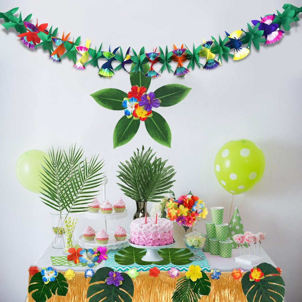 Tropical party table setting with cake, cupcakes, balloons, and floral decorations.