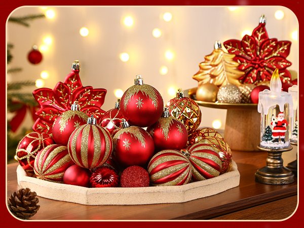 Assortment of red and gold Christmas ball ornaments and decorative poinsettias on a tray, with a Santa candle decoration.
