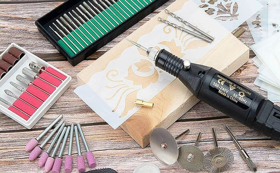 Electric engraver tool kit with various bits, stencils, and a wooden block for crafting