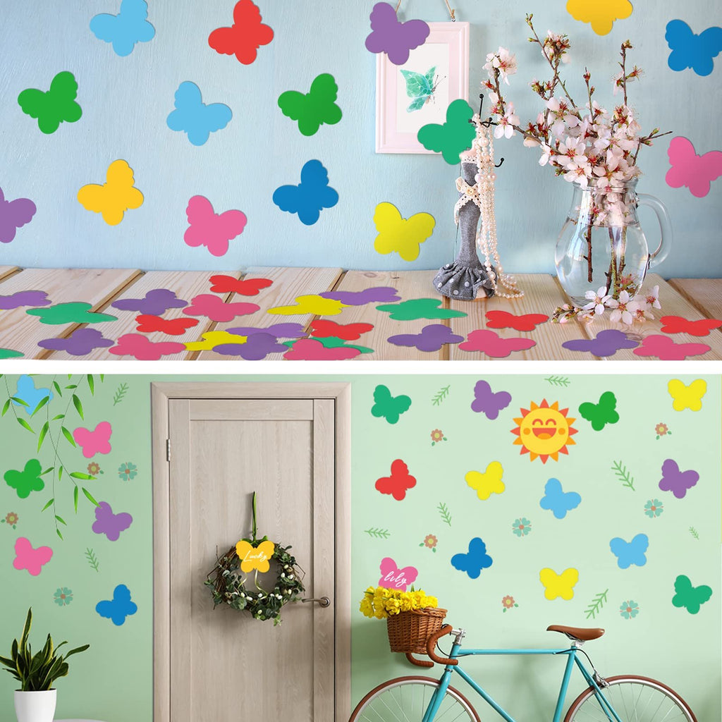 Colorful paper butterfly cutouts decorating a wall and scattered on a wooden surface, with a bicycle and wreath in the background.