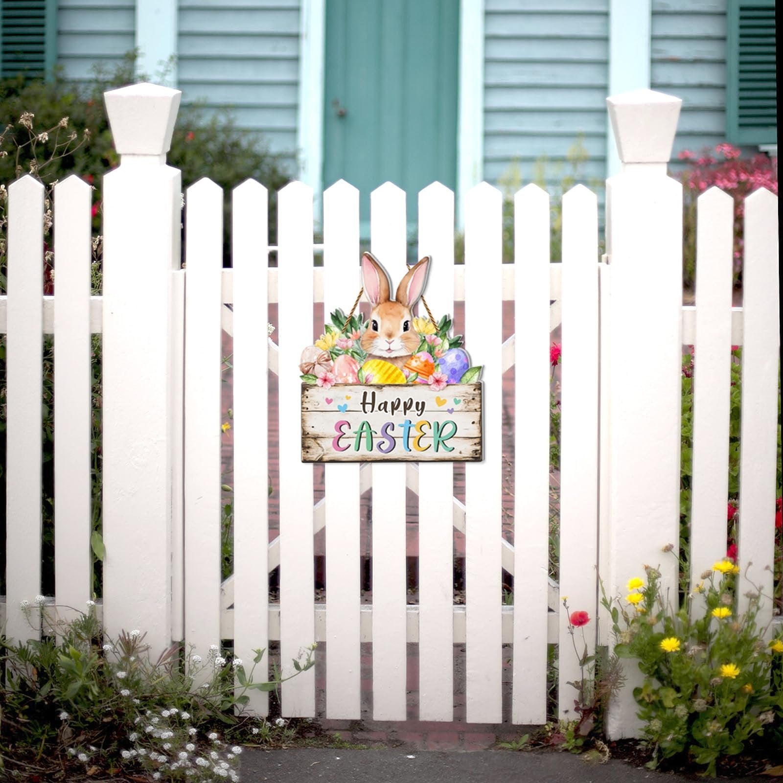 Easter door sign with bunny and eggs hanging on a white picket fence