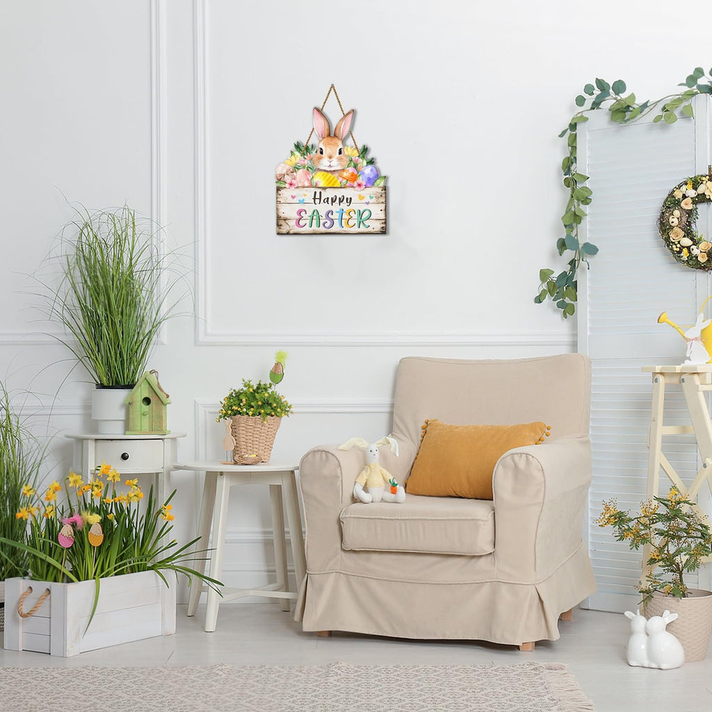 Easter door sign with bunny and eggs hanging on a white wall, next to a chair and plants.