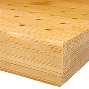 Bamboo blocking board with many small holes and layered wood grain, close-up corner view.