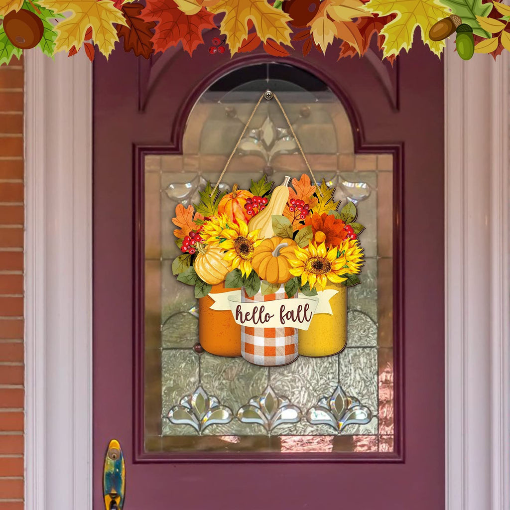 Fall welcome sign with sunflowers, pumpkins, and maple leaves hanging on a door.