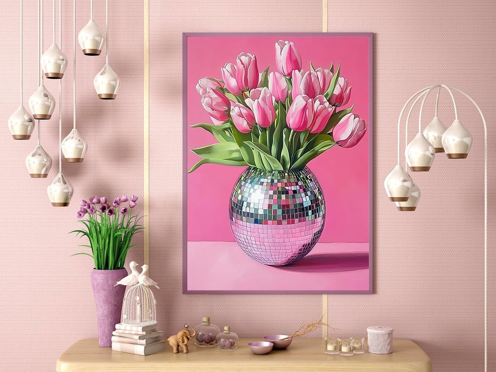 Pink tulips in a disco ball vase, framed and displayed on a pink wall with decorative items on a table below.