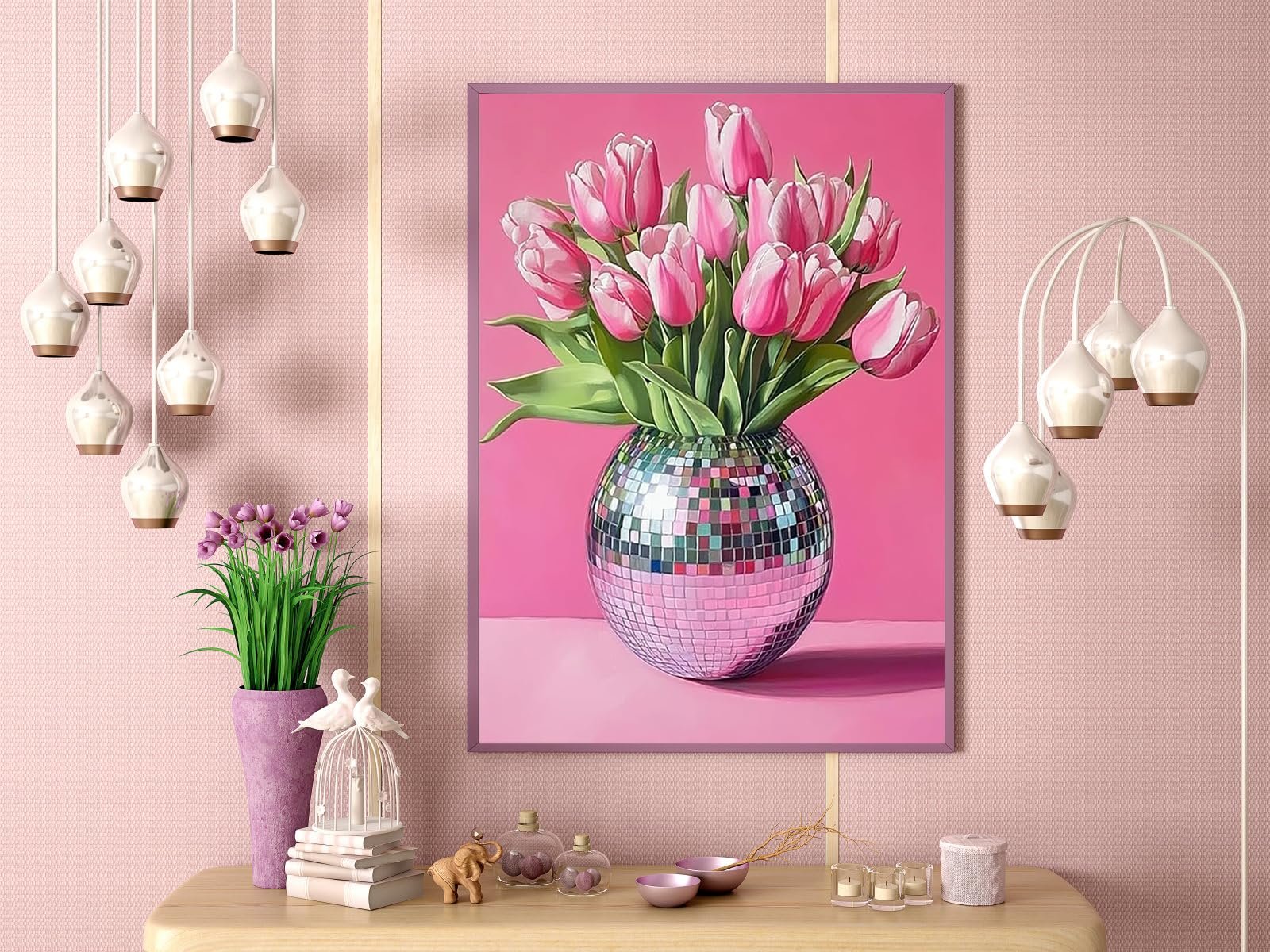 Pink tulips in a disco ball vase, framed and displayed on a pink wall with decorative items on a table below.
