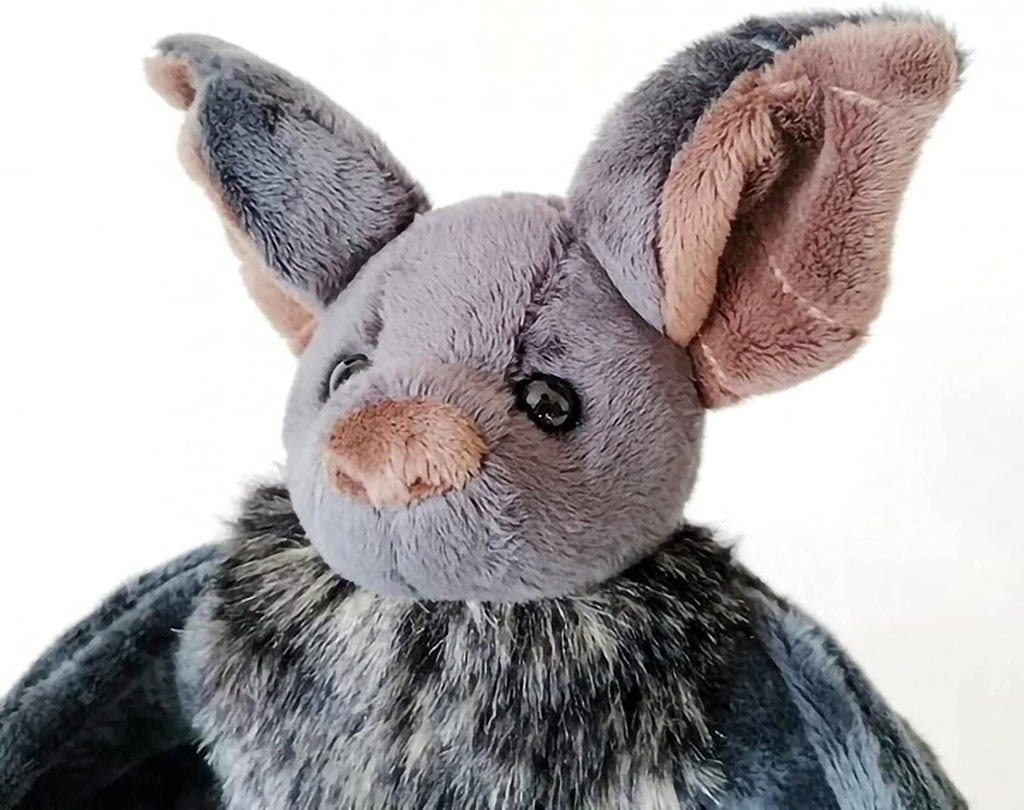 Close-up of a grey plush bat stuffed animal with large pink-lined ears and a fluffy grey and black neck ruff.
