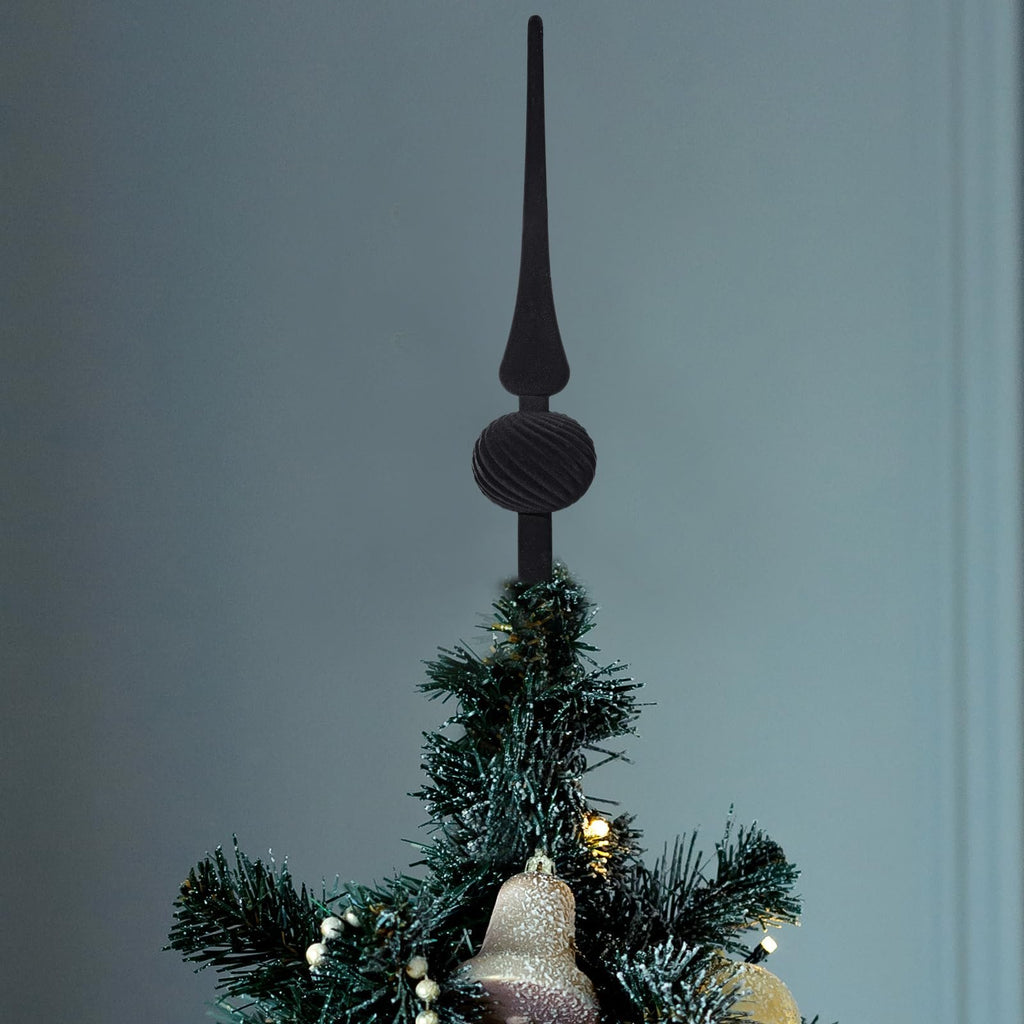Black velvet finial Christmas tree topper with a spherical ornament, placed on top of a decorated evergreen tree.