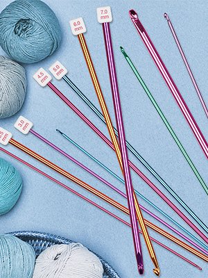 Set of multicolor aluminum crochet hooks with size labels and balls of yarn on a blue background.