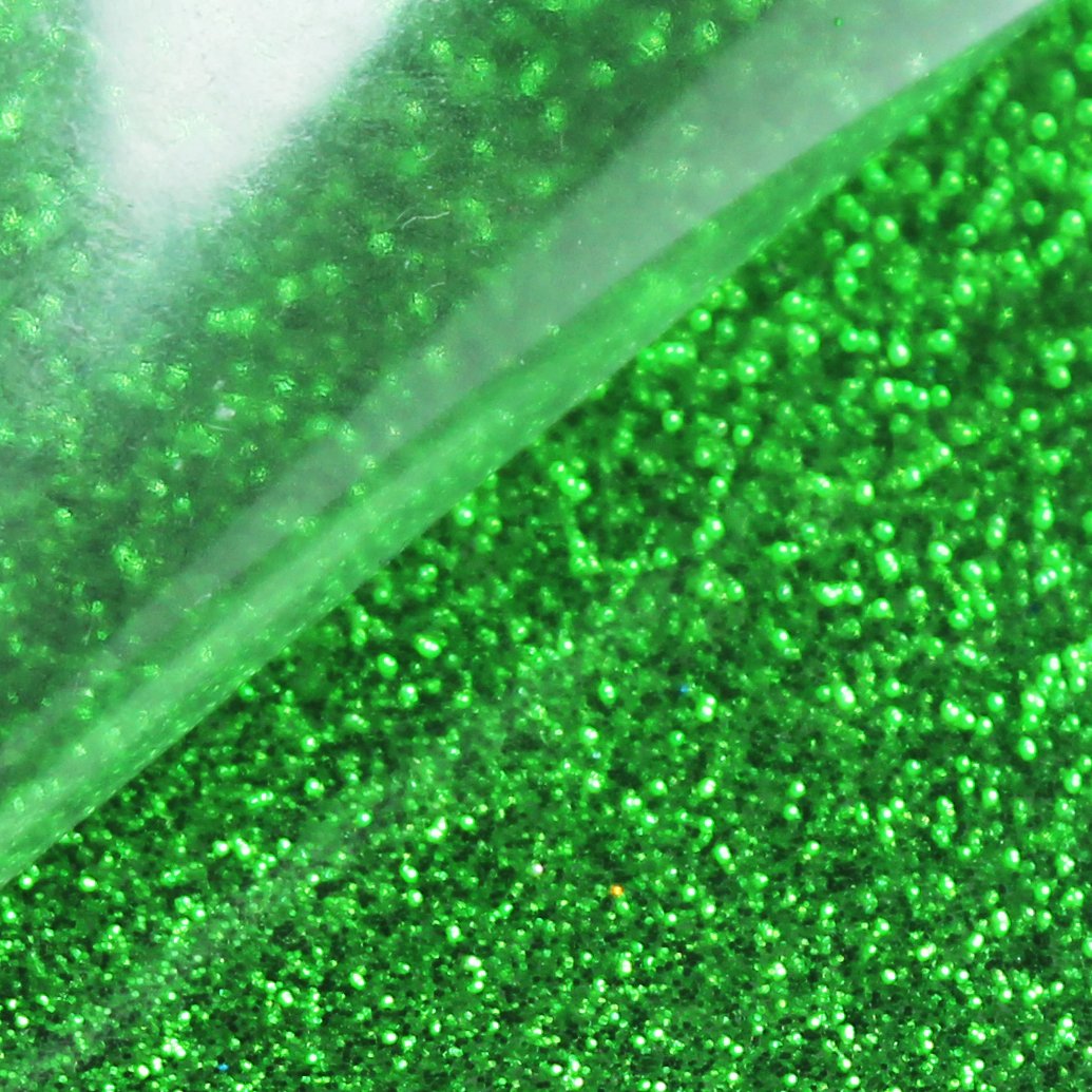 Close-up of green glitter heat transfer vinyl sheets with a clear protective layer.