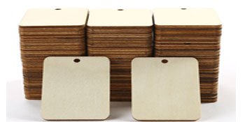Stack of unfinished wood rectangle cutouts with holes for hanging, two in foreground