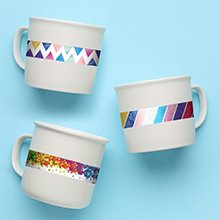 Three white ceramic mugs decorated with colorful patterned adhesive trim on a light blue background.