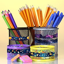 Desk organizers filled with colored pencils, pens, and pencils, decorated with space-themed tape.