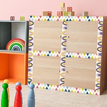 Bulletin board border trim with rainbow and triangle patterns applied to cabinet doors in a playroom setting.