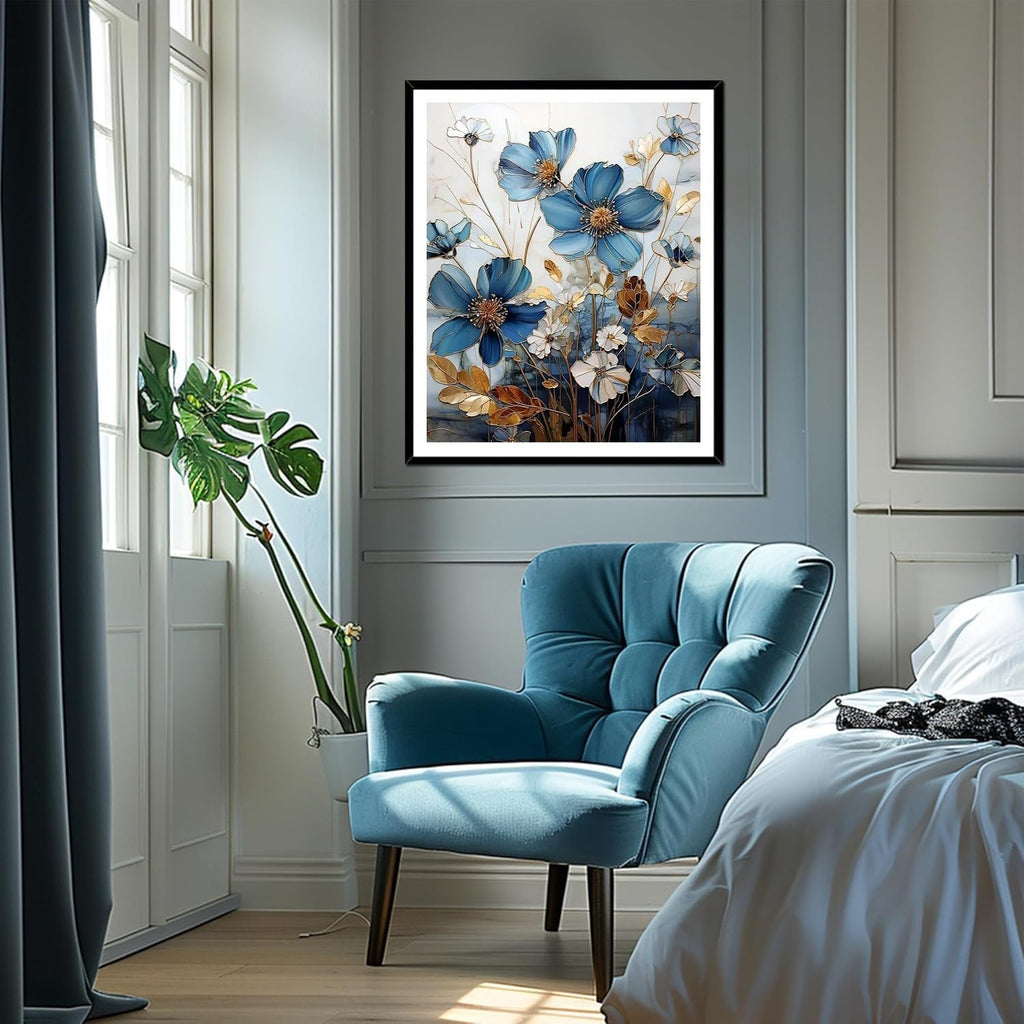 Framed blue floral cross stitch artwork hanging above a blue armchair next to a bed.