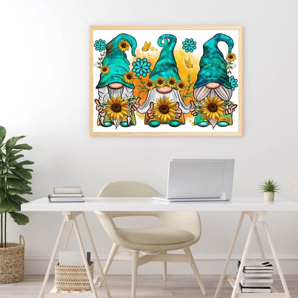 Three gnomes holding sunflowers in a framed picture on a wall above a desk.