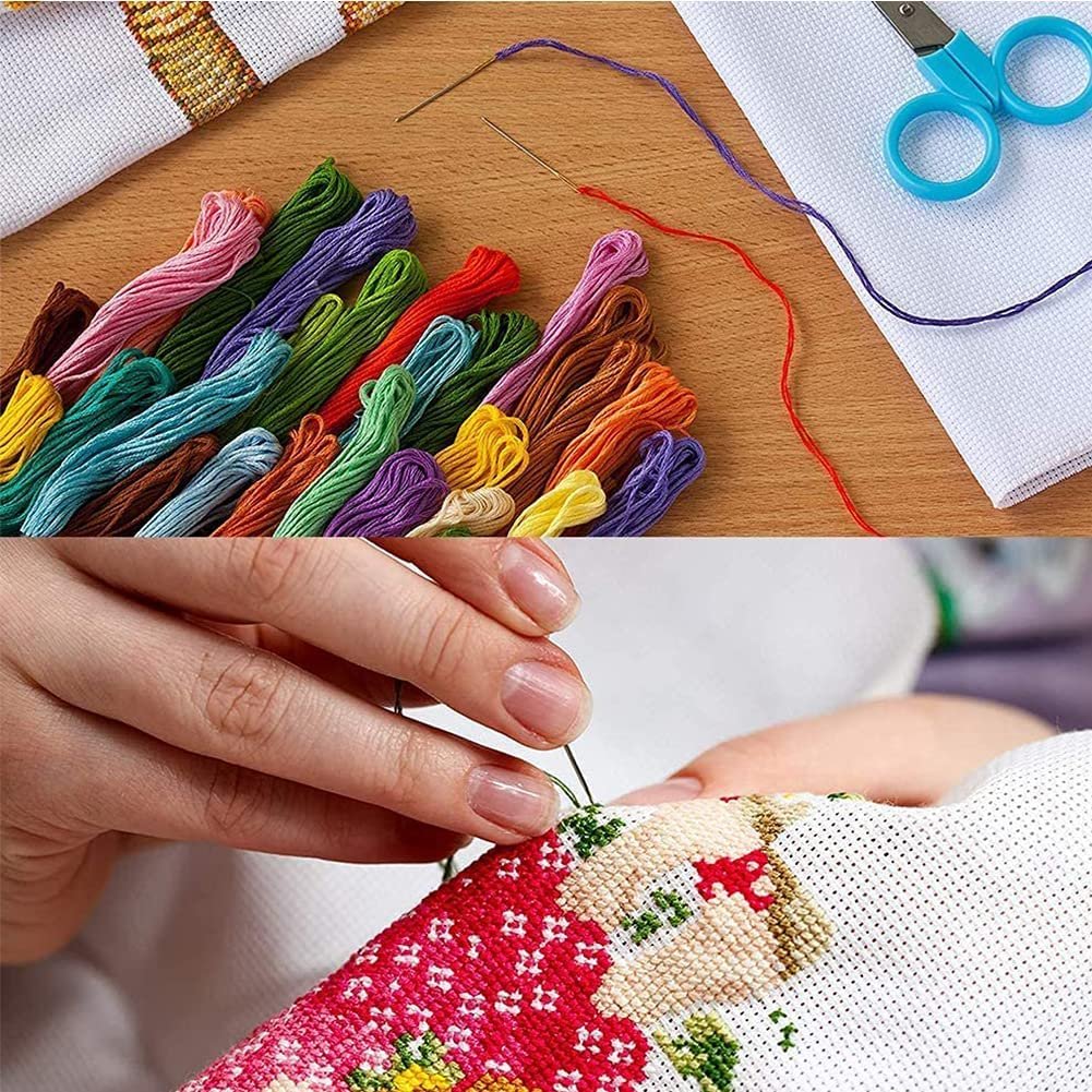 Cross stitch kit with colorful threads, needles, scissors, and fabric being stitched by hands.
